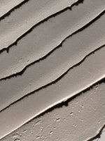 Close-up texture of charcoal deodorant showcasing smooth application lines, highlighting the benefits of deodorant with charcoal.