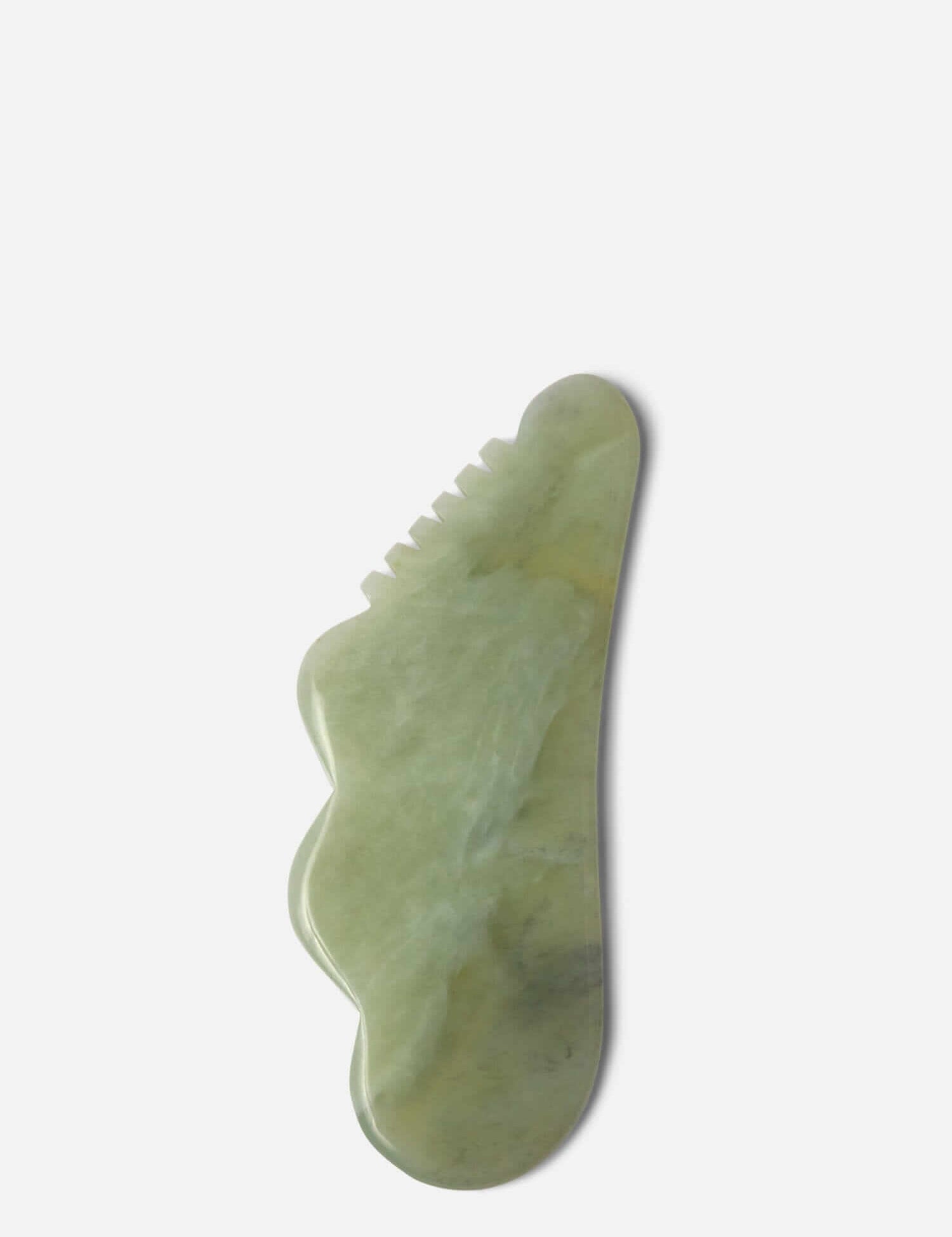 Green gua sha stone with a unique shape, designed for facial and body massage to promote circulation and reduce tension.
