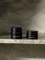 Two jars of Primally Pure Everything Balm, a tallow-based multi-purpose balm, sitting on a marble shelf.