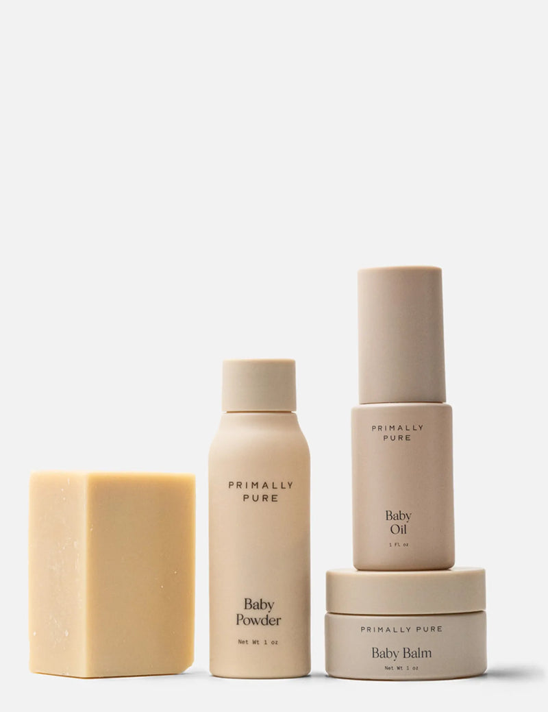 Collection of Primally Pure baby care products including baby bar, talc free baby powder, baby oil, and baby balm on a white background.