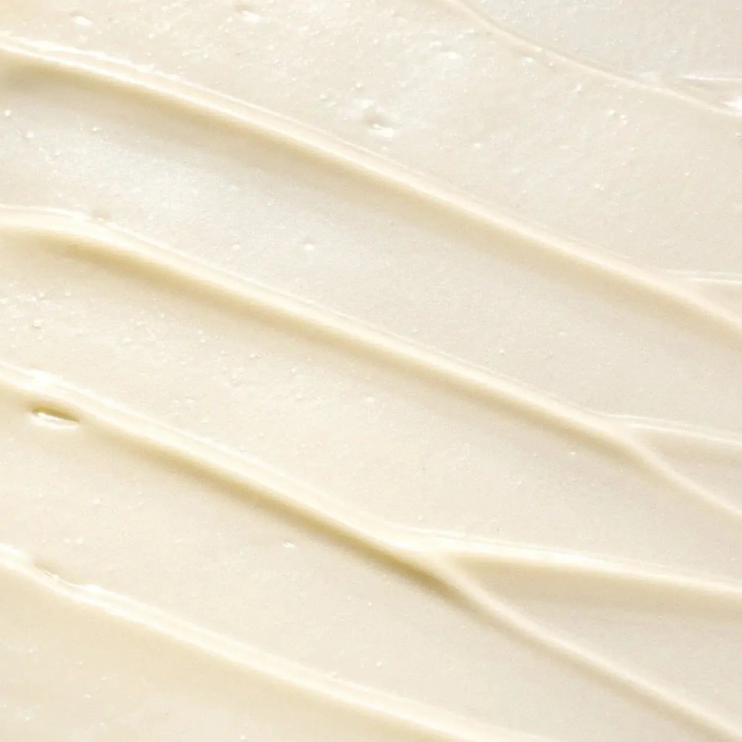 A close-up texture shot of a smooth, creamy off-white Bergamot + Eucalyptus Body Butter with diagonal swirled strokes.