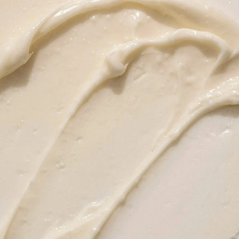 A close-up texture shot of Citrus Mint Body Butter a creamy off-white body butter with smooth swirled strokes.