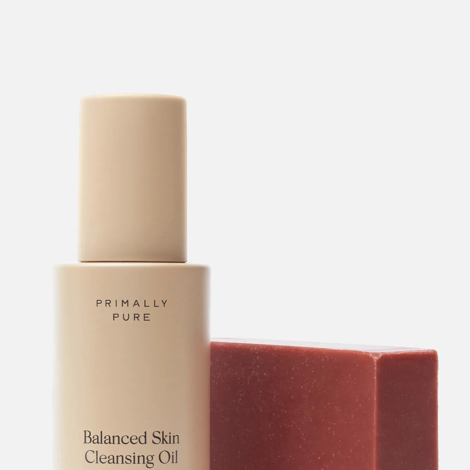 Primally Pure Double Cleansing Kit (Plumping) Bundle in a warm beige tone next to a red rectangular bar Plumping Bar Face Soap Bar, on a clean white background.