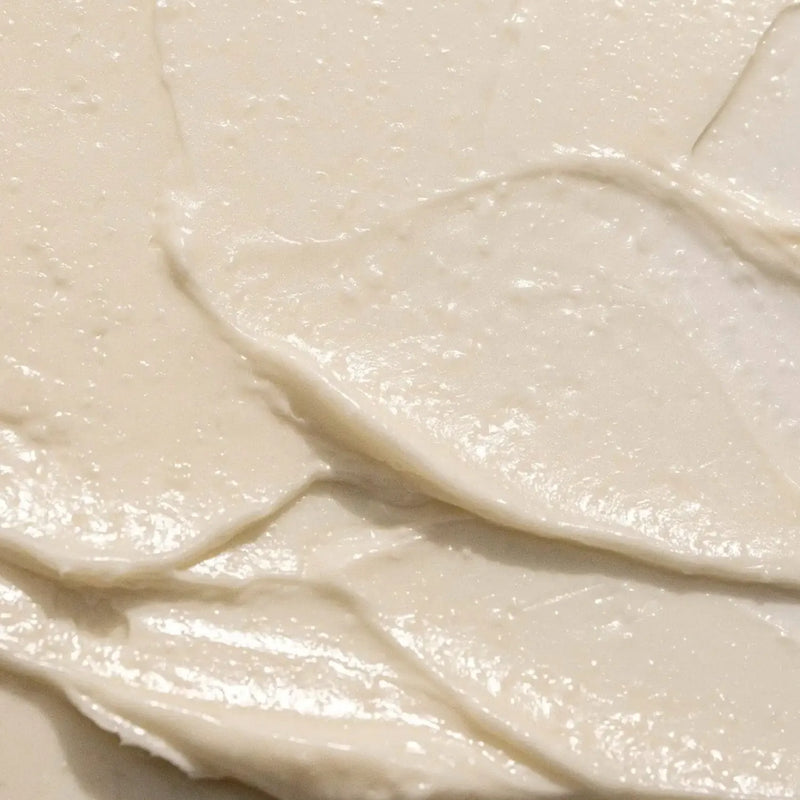 A close-up texture shot of Eucalyptus Lavender Body Butter a creamy off-white Body Butter with smooth, swirled strokes and a glossy finish