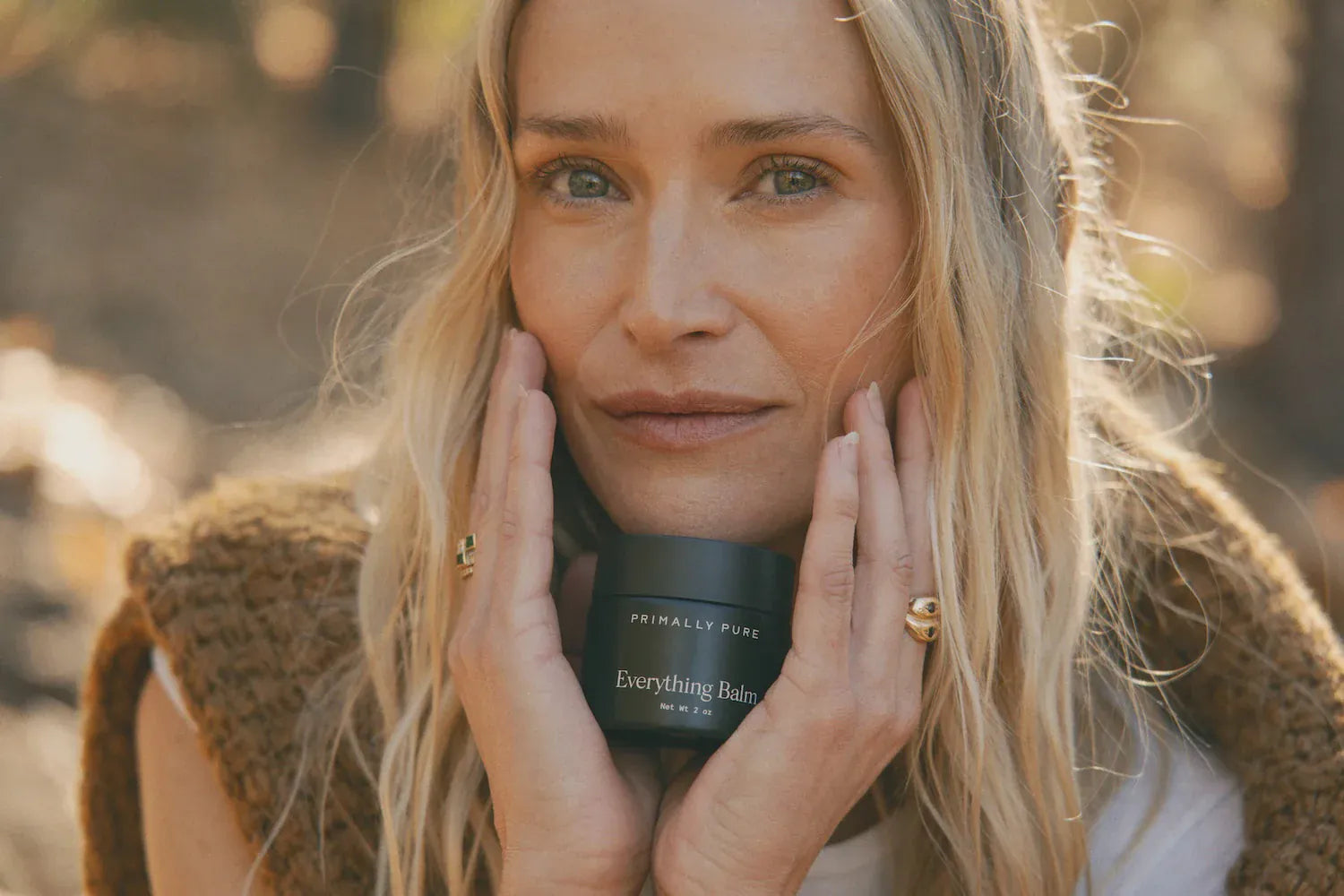 Woman holding Primally Pure Everything Balm a tallow balm great for hydrating dry skin