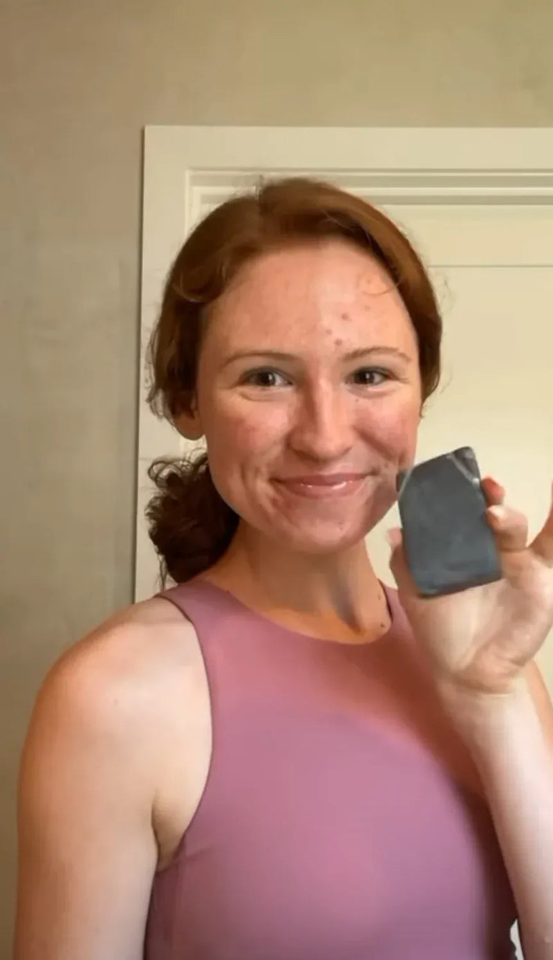 Woman holding a Primally Pure Clarifying Bar Skin Specific Face Cleansing Bar in front of a neutral background