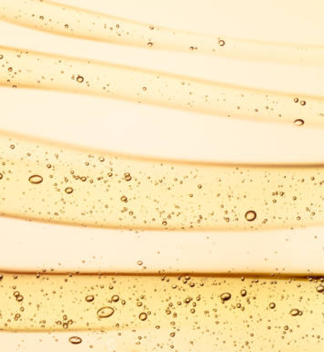 Close-up of emu oil with a smooth golden texture and small air bubbles