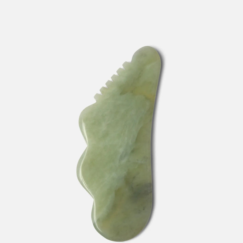 Green gua sha stone with a unique shape, designed for facial and body massage to promote circulation and reduce tension.