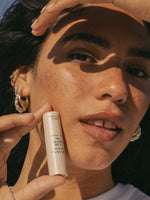 Sun Lip Balm SPF 15 Sunscreen Primally Pure Model holding Mineral SPF Lip Balm